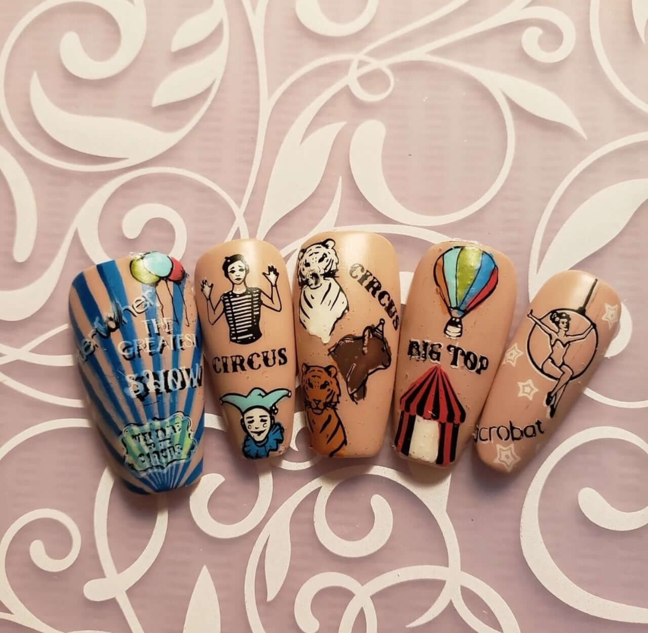 set-of-nail-tips-with-bright-colorful-circus-nail-art-designs-of-big-top-acrobat-mime-artist-and-the-words-the-greatest-show