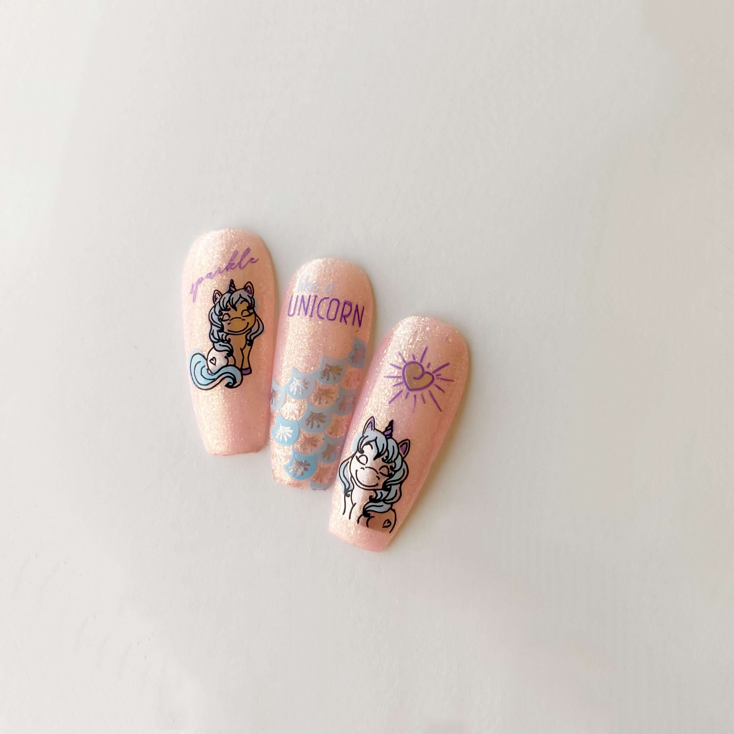 three-manicured-nail-tips-showing-cute-unicorn-nail-art-designs