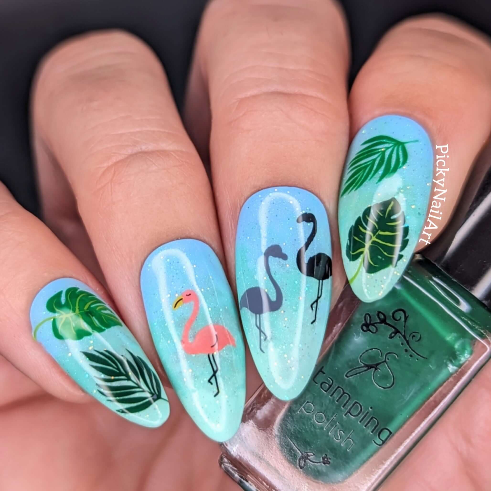 shimmering-blue-manicure-with-nail-art-designs-of-pink-flamingos-and-palm-leaves