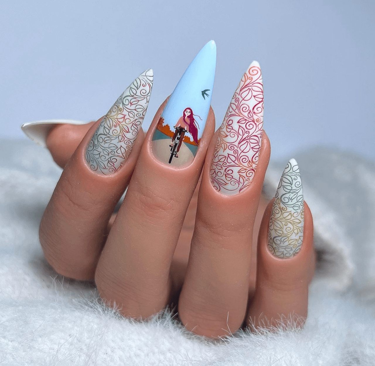 beautiful-manicure-of-a-girl-riding-a-bike-and-designs-of-swirly-leaves