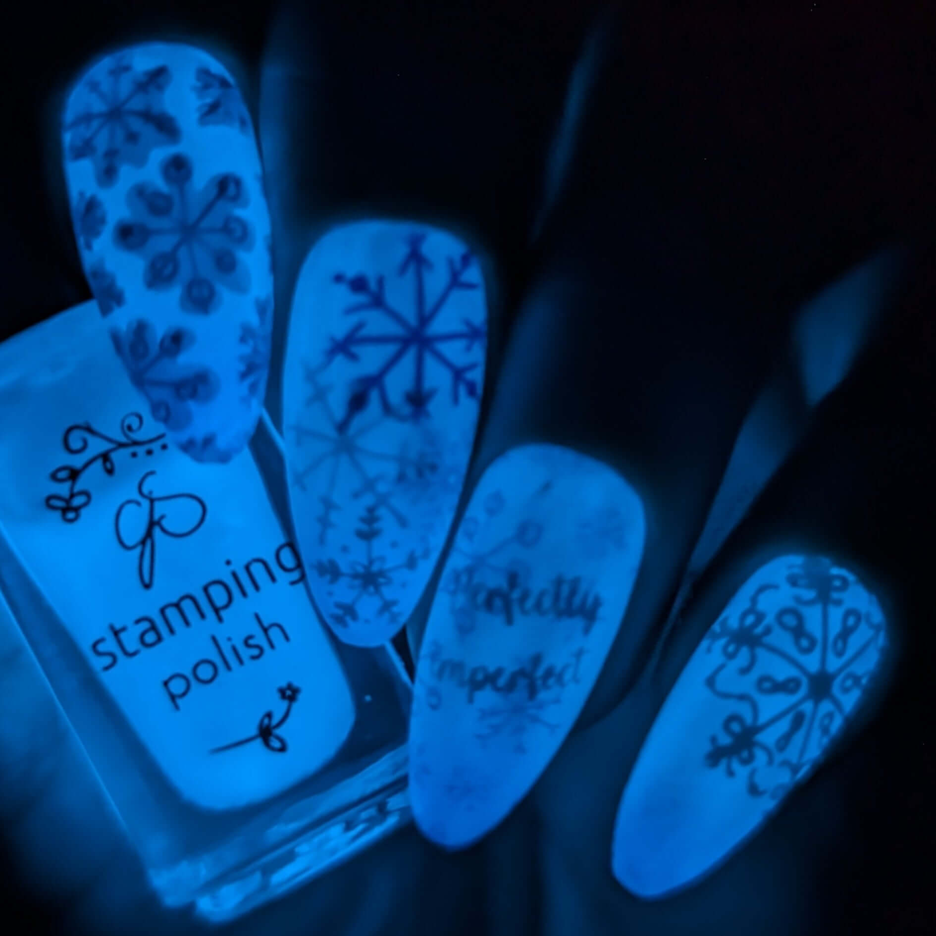 beautiful-manicure-showing-glow-in-the-dark-nail-art-designs-of-snowflakes-and-the-words-perfectly-imperfect