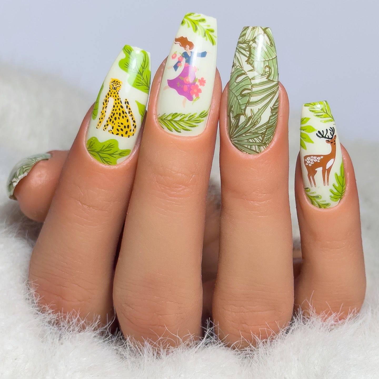 manicured-hand-showing-layered-nail-art-designs-of-tropical-leaves-and-a-women-dancing