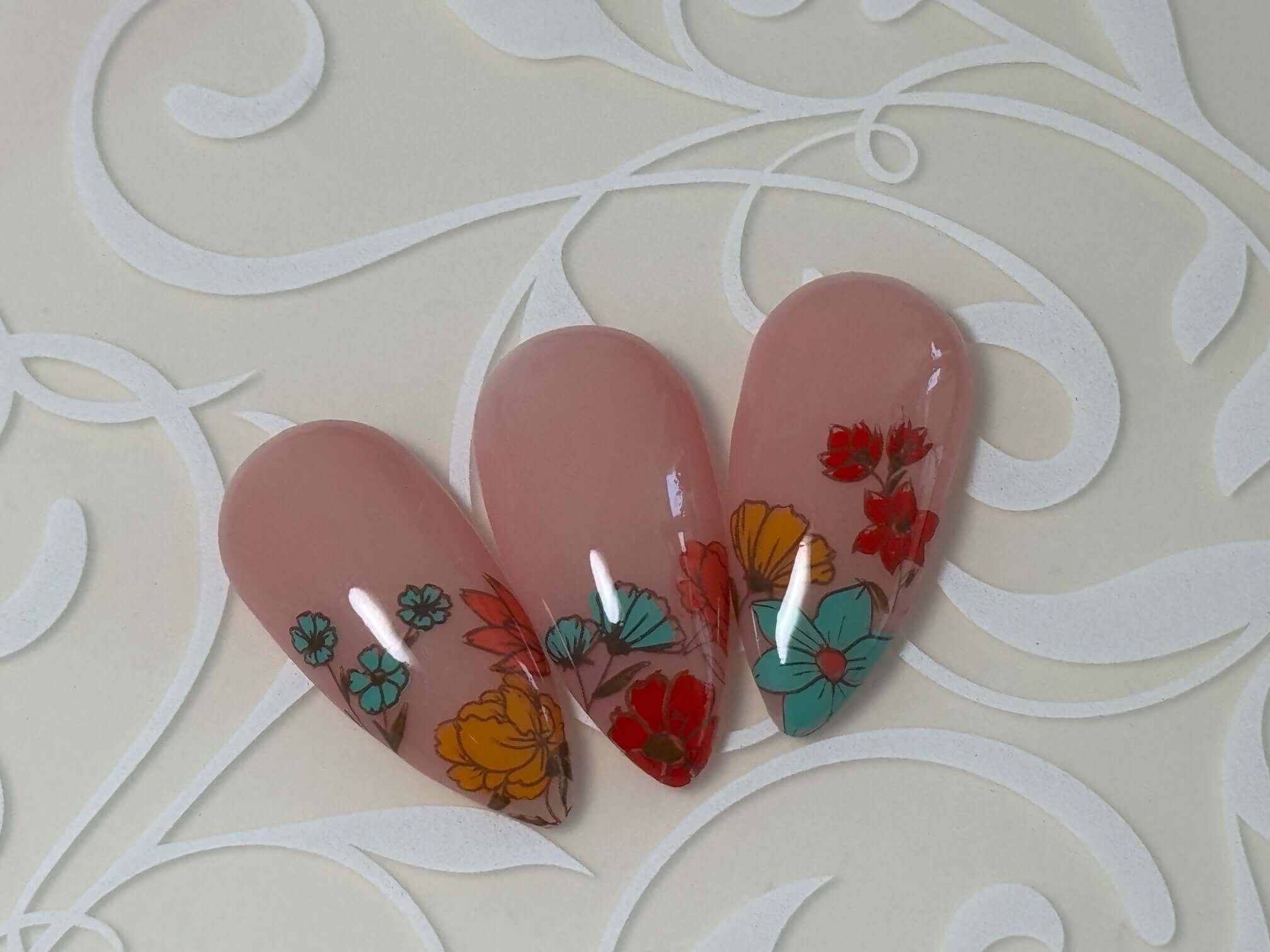 Three-nail-tips-showing-a-nail-art-design-of-colorful-flowers