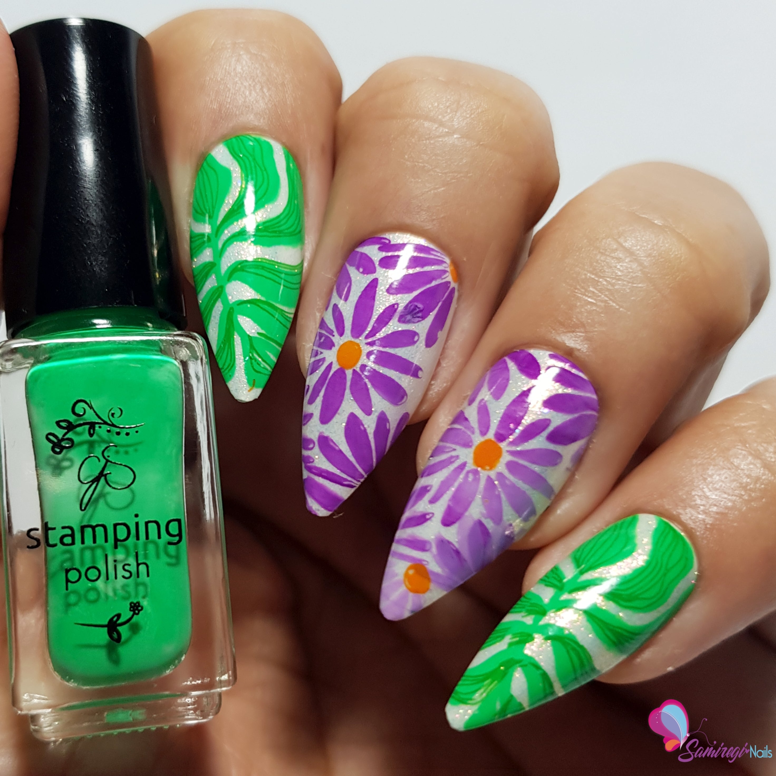 manicured-hand-holding-bottle-of-nail-stamping-polish-with-abstract-flower-nail-art-designs-on-the-nails