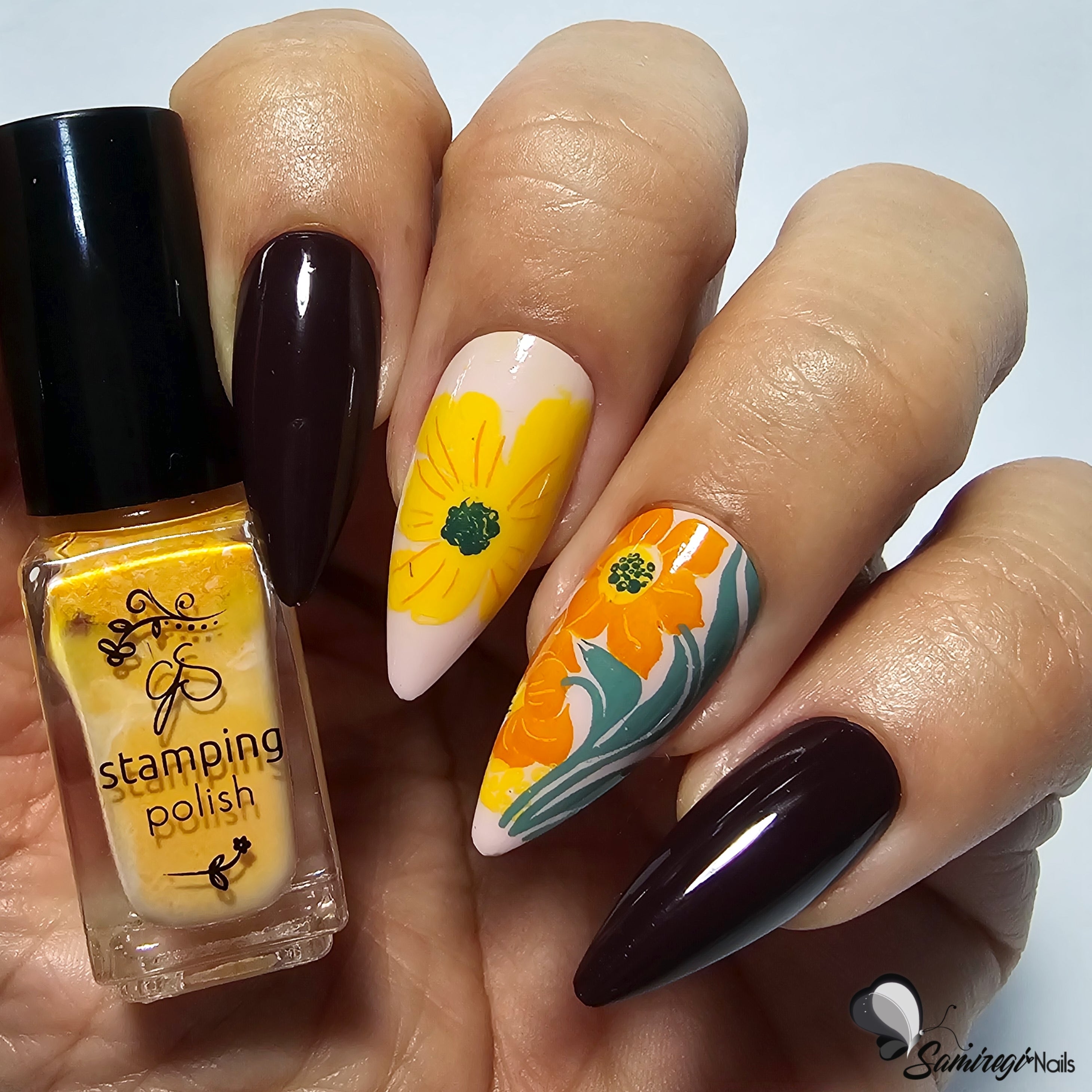 manicured-hand-holding-bottle-of-nail-stamping-polish-showing-abstract-flower-nail-art-designs