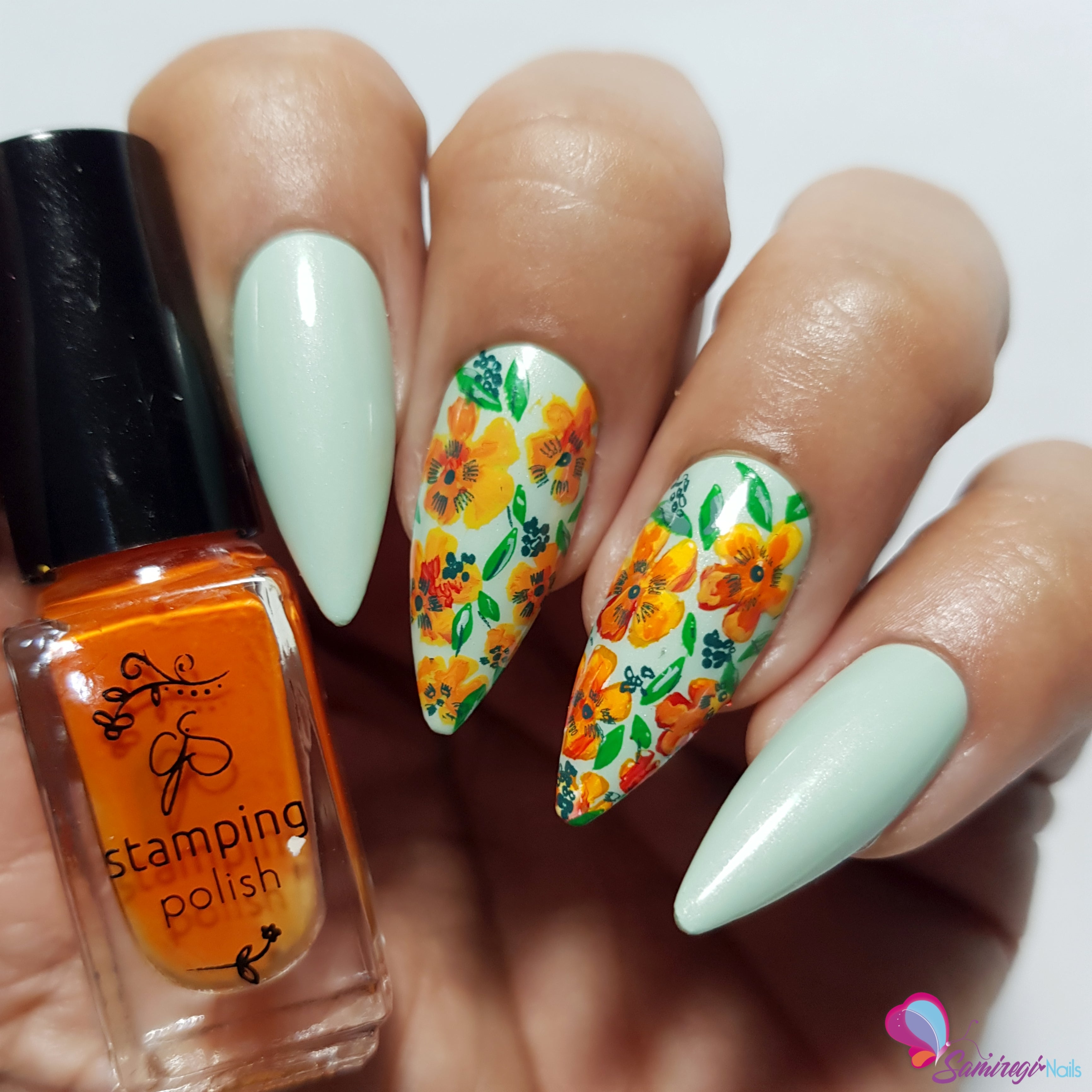 manicured-hand-holding-bottle-of-nail-stamping-polish-with-full-coverage-abstract-flower-nail-art-designs-on-the-nails