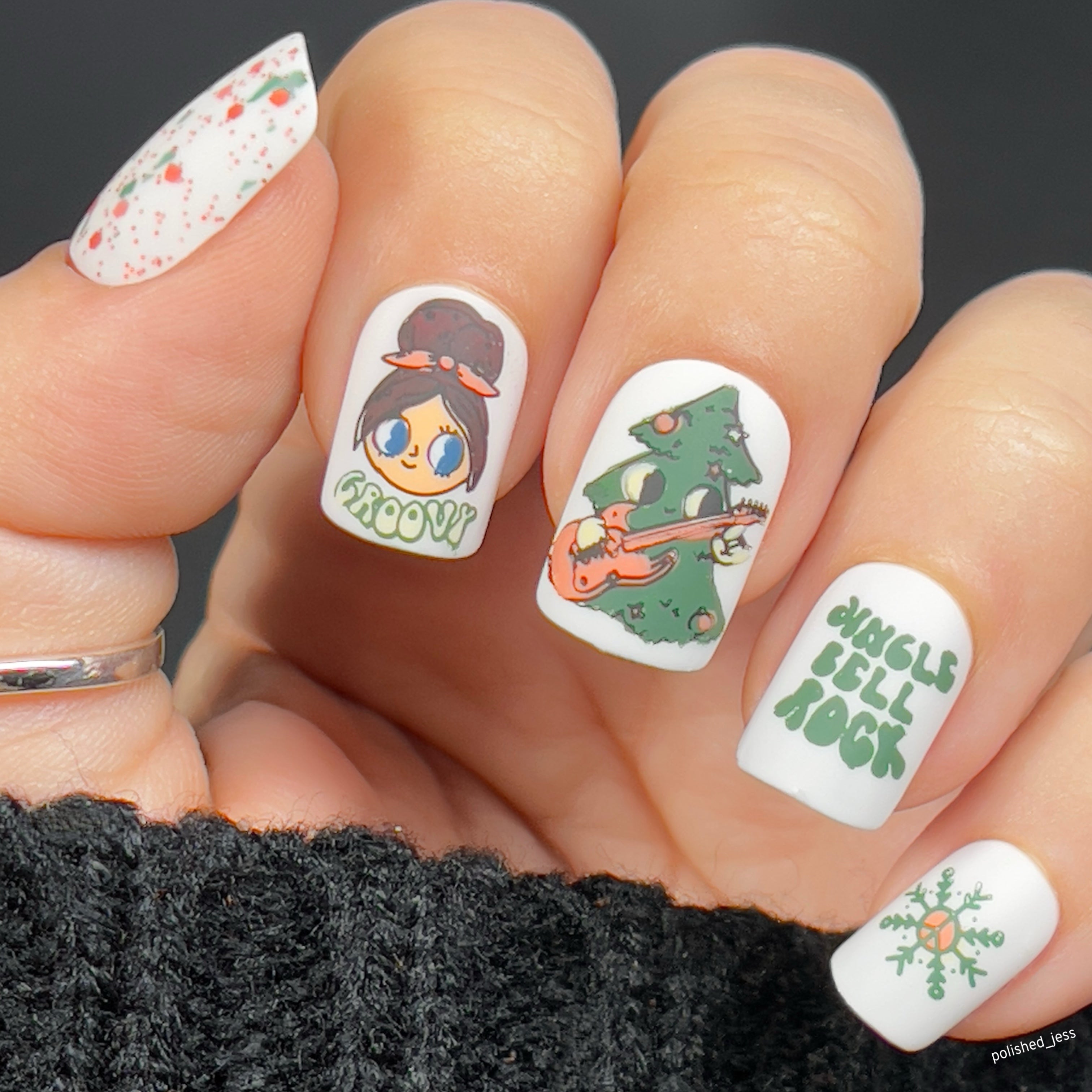 manicured-hand-with-cute-nail-art-designs-of-a-cartoon-christmas-tree-playing-a-guitar-and-the-words-jingle-bell-rock