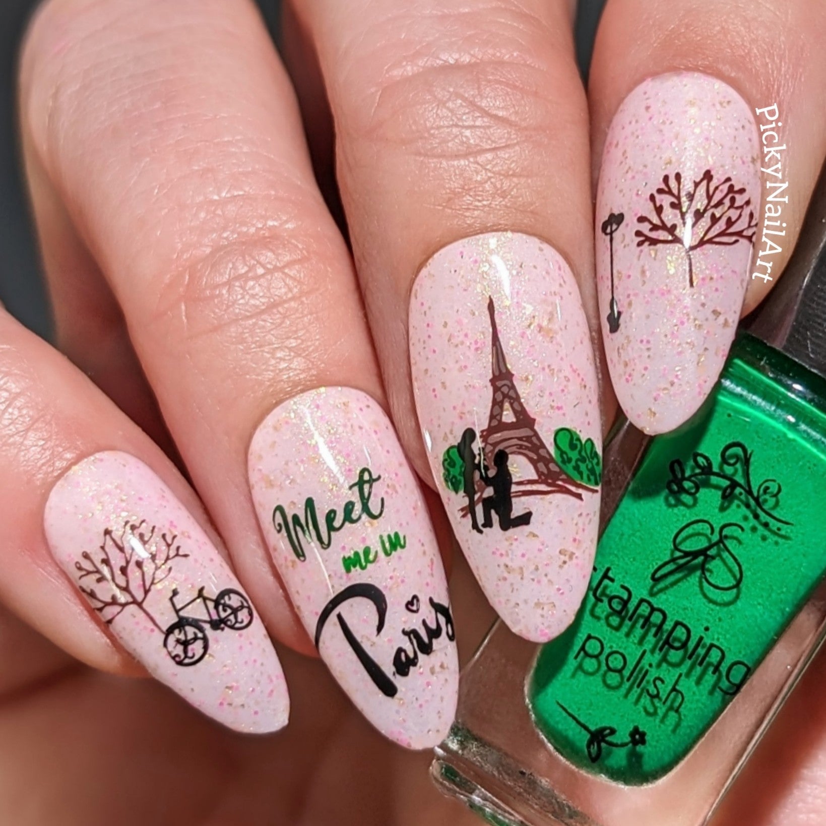 manicured-hand-holding-a-stamping-polish-bottle-The-hand-has-nail-art-designs-of-theeffiel-tower-a-couple-proposing-and-works-meet-me-in-paris