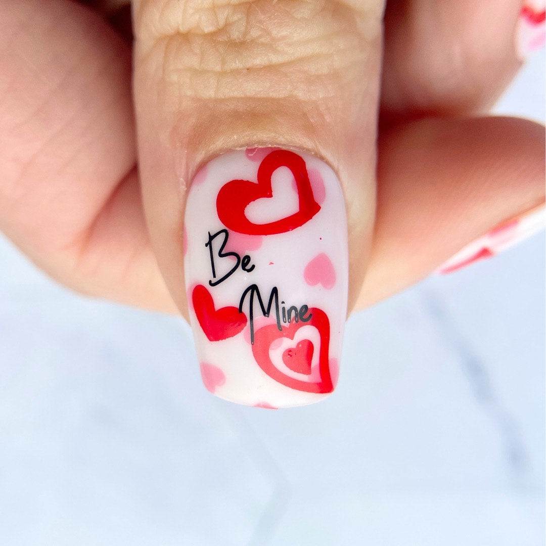 manicured-thumb-with-stunning-valentines-nail-art-design-of-hearts-and-the-words-be-mine