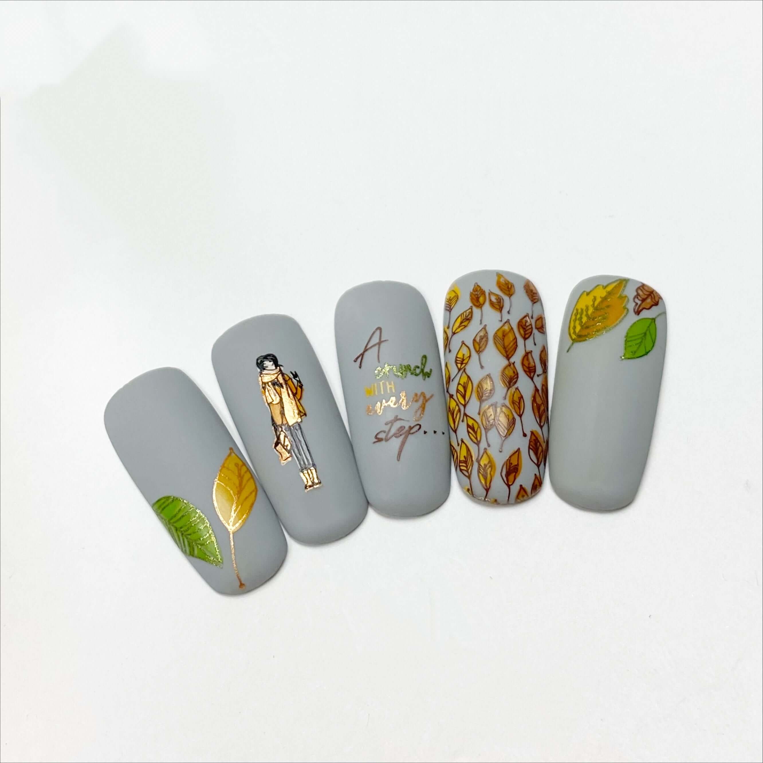 set-of-nail-tips-with-nail-art-designs-of-fall-leaves-a-girl-and-the-words-a-crunch-with-every-step