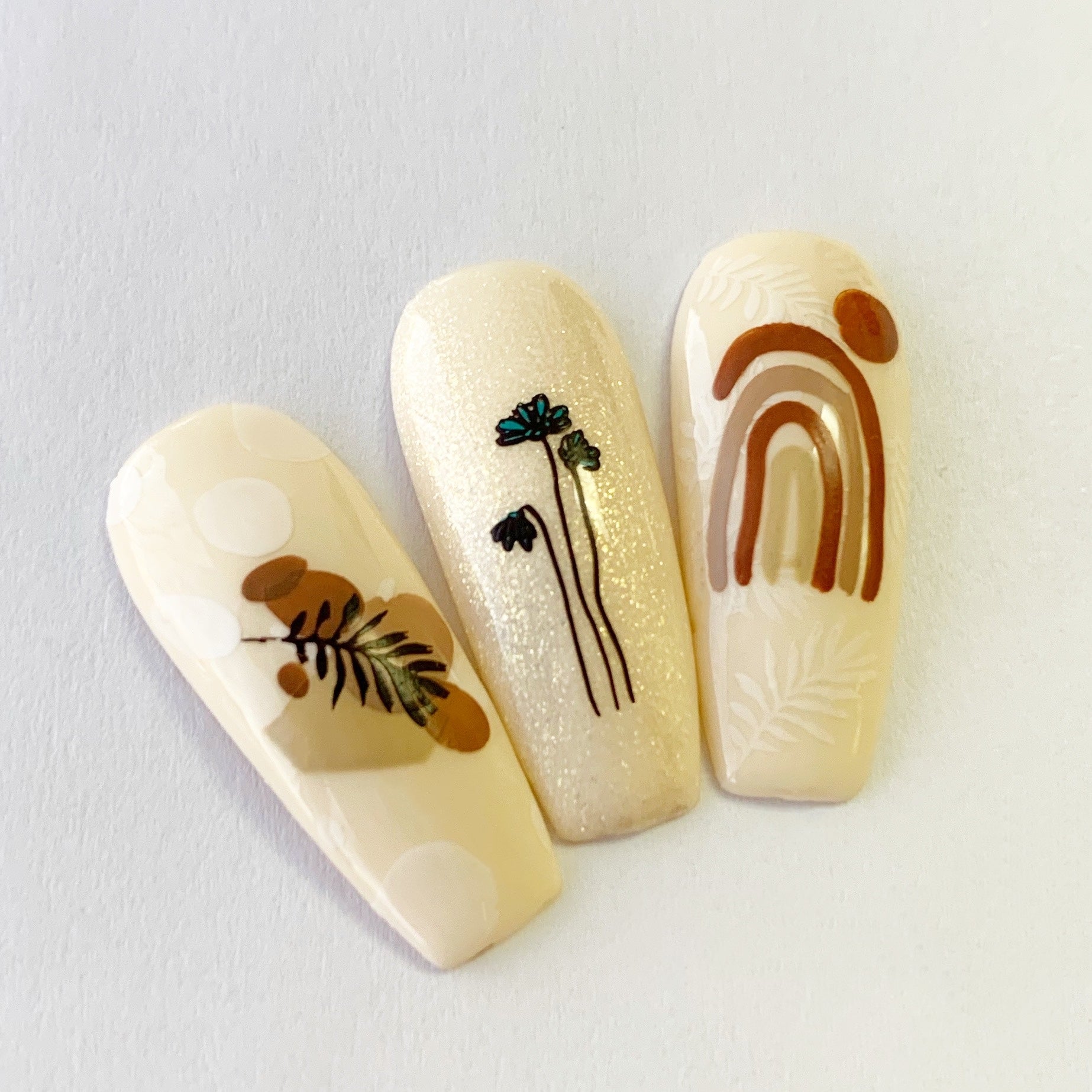 set-of-three-nail-tips-with-abstract-boho-nail-art-designs-of-arches-blobs-and-flower-stalks