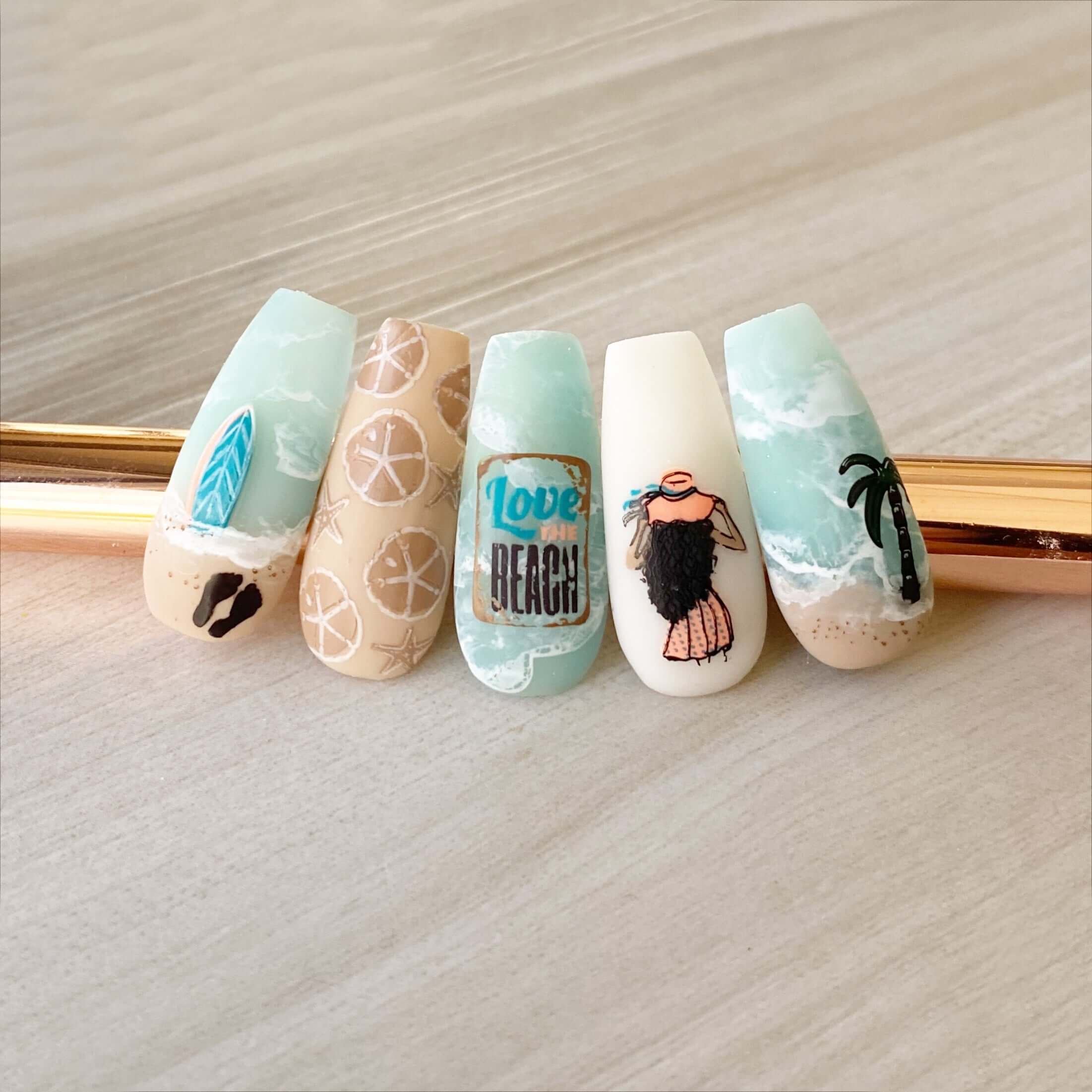 set-of-nail-tips-showing-nail-art-designs-of-a-beach-with-waves-and-palm-trees