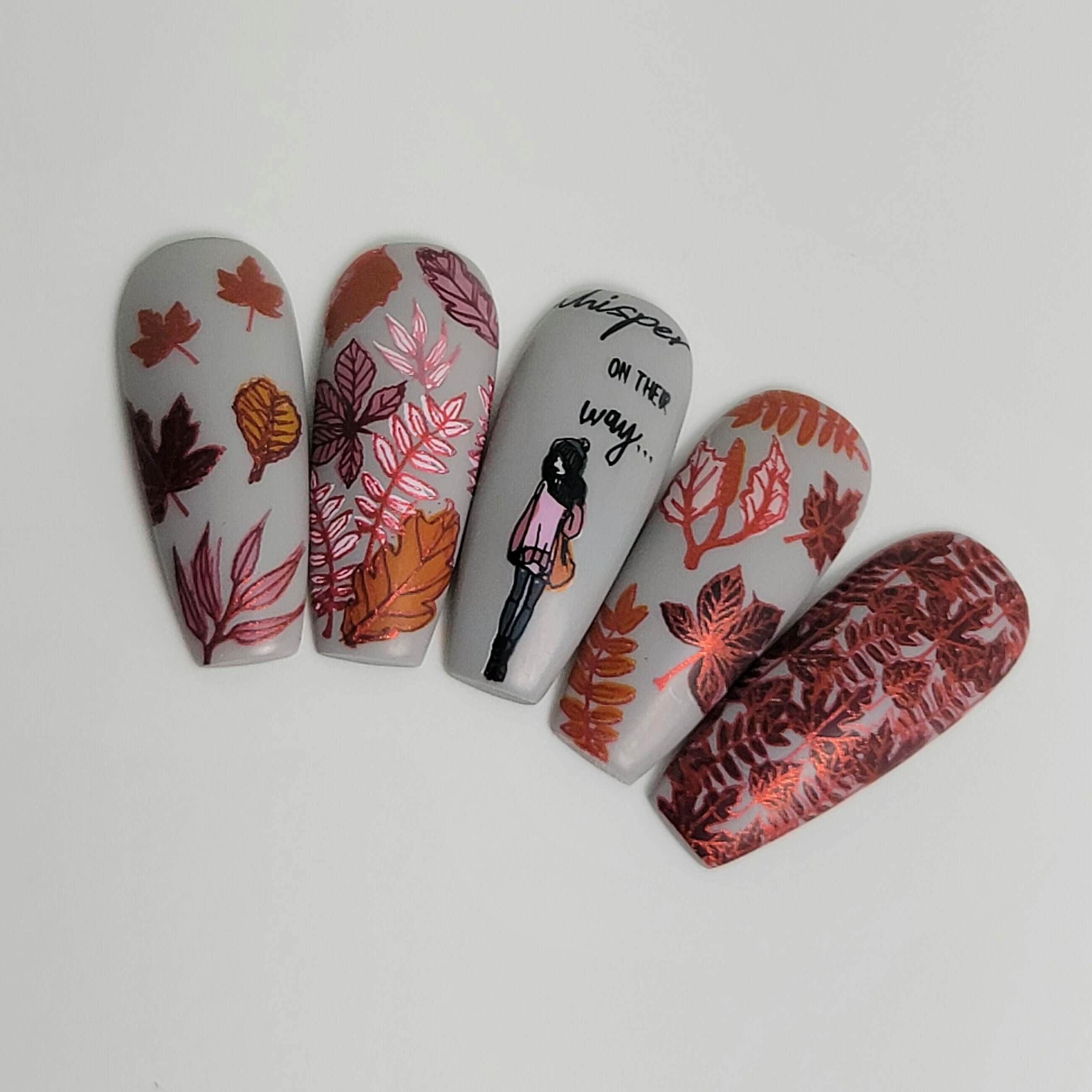 set-of-nail-tips-with-beautiful-nail-art-designs-of-autumn-leaves-a-girl-in-hat-andscarf-and-the-words-whisper-on-their-way