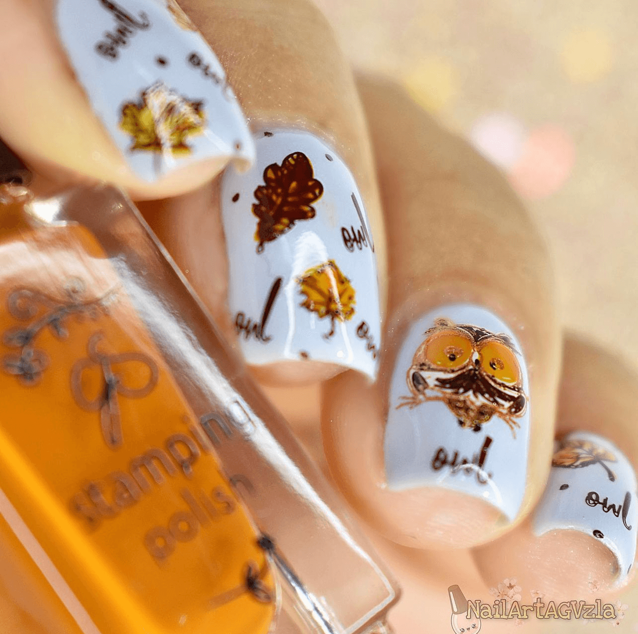 manicure-showing-nail-art-designs-of-an-owl-with-leaves-holding -a-bottle-of-stamping-polish