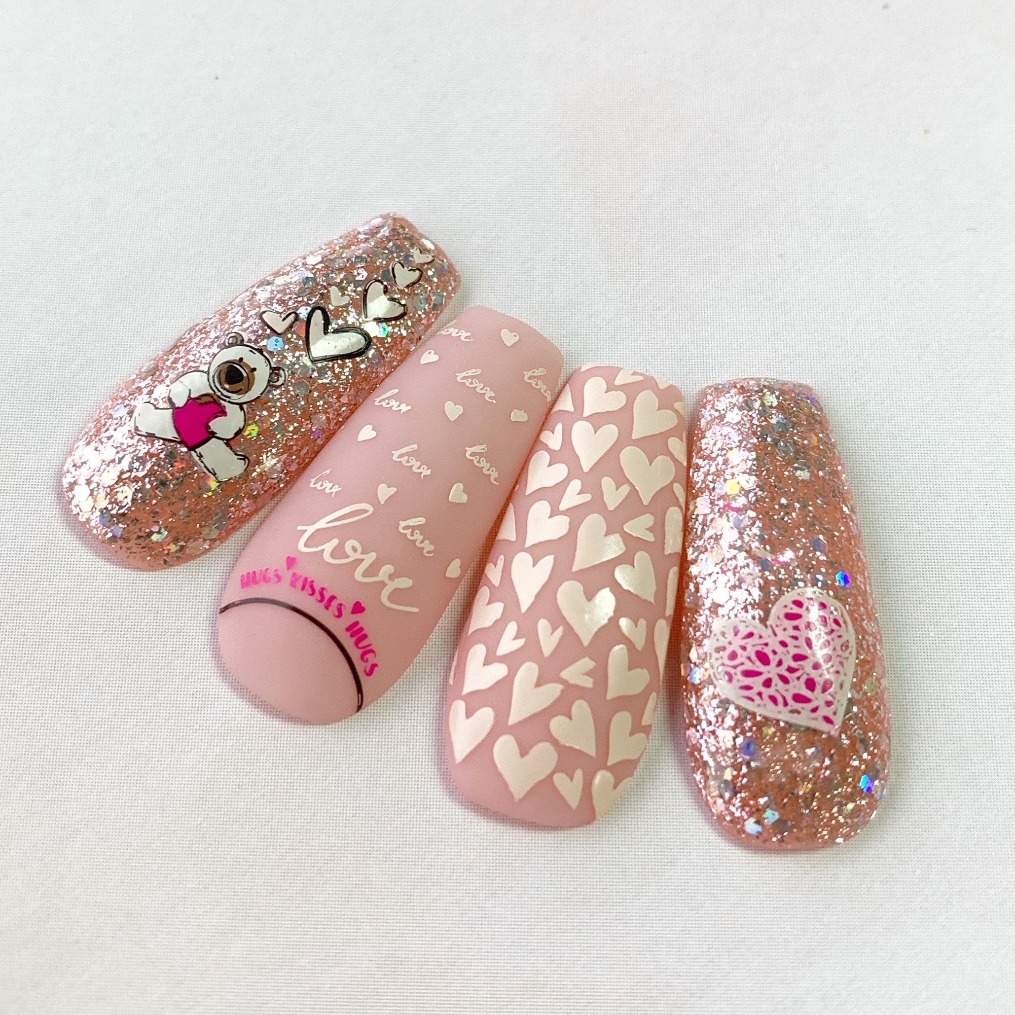 set-of-nail-tips-with-valentines-nail-art-designs-of-hearts-a-teddy-bear-and-words-love