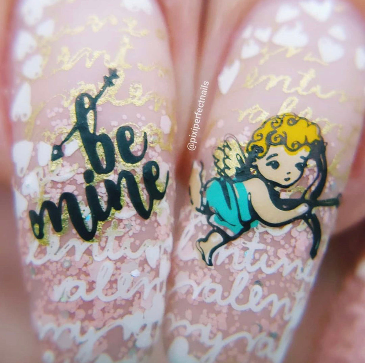 two-nail-tips-with-layered-nail-art-designs-of-a-cupid-and-words-be-mine