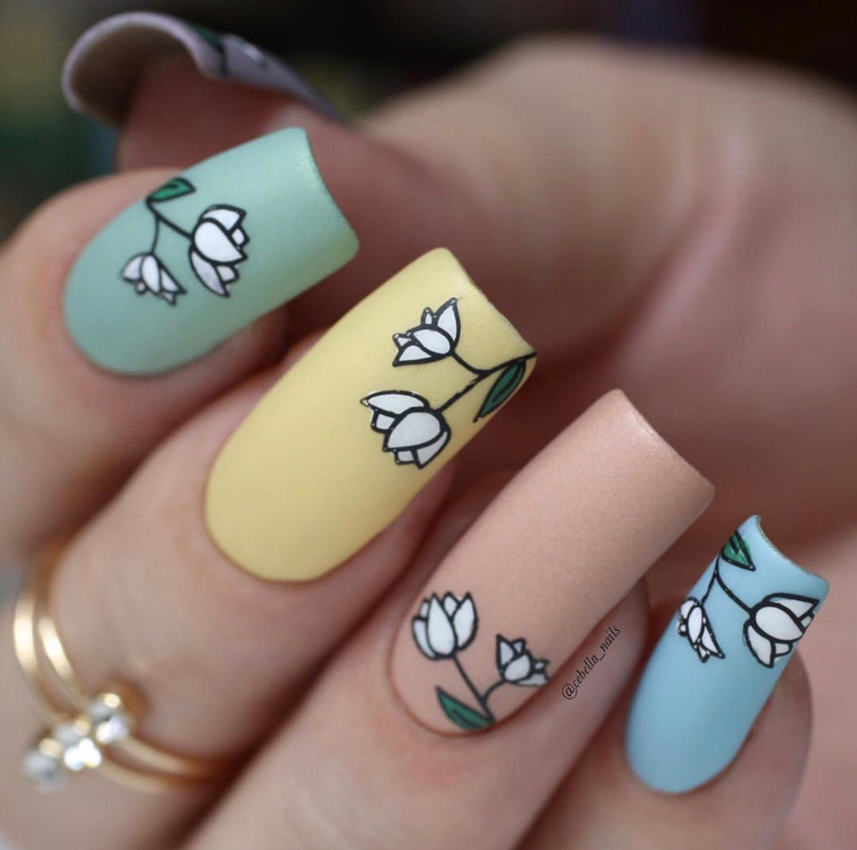 manicured-hand-with-nail-art-stamping-designs-of-spring-flowers