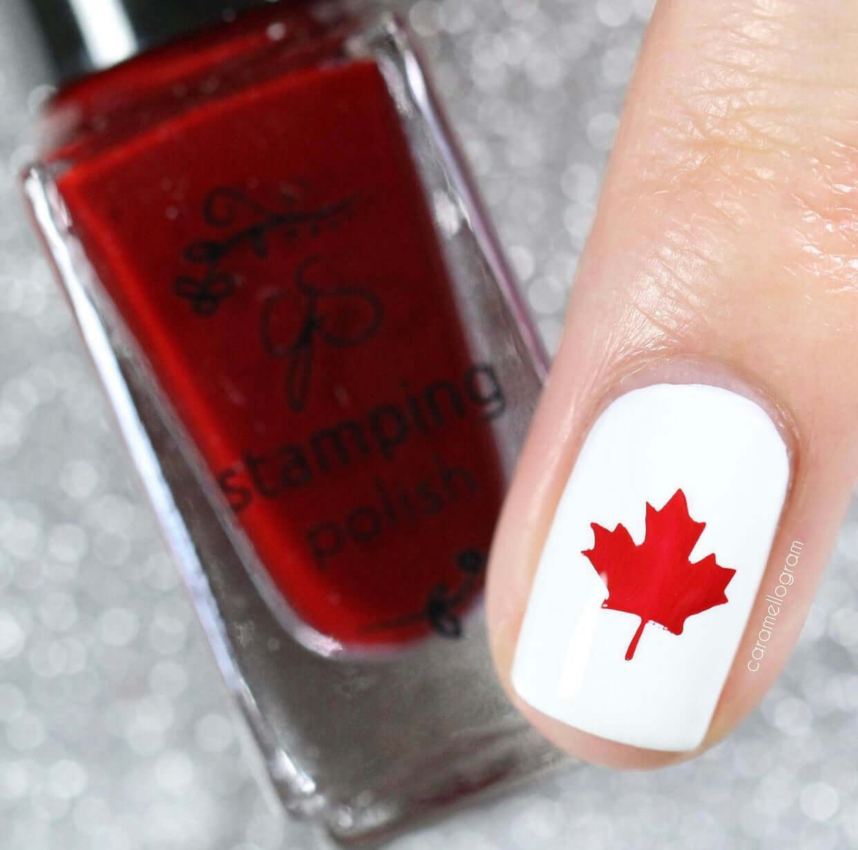 single-manicured-nail-showing-a-maple-leave-in-nail-art-with-a-bottle-of-red-stamping-polish